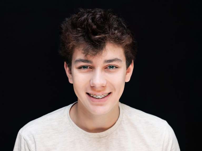 An image of a young man smiling with braces on in Erina